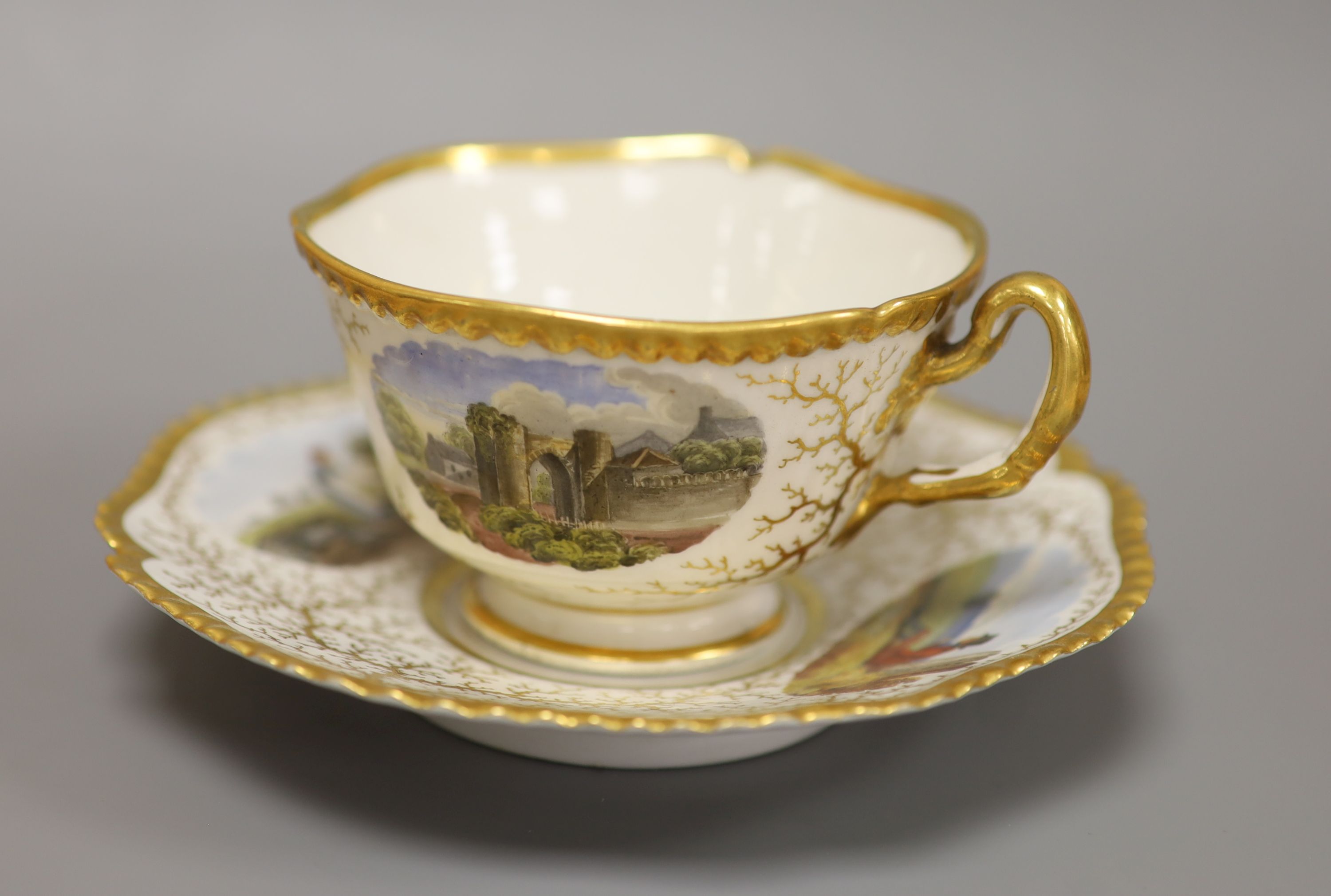 A Flight Barr & Barr cup and saucer, painted with Binstead cottage, Isle of White and Land Gate, Winchelsea, the saucer with country folk diameter 15cm